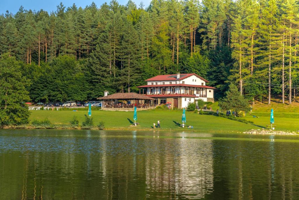 una casa grande en una colina junto a un lago en Palitsi Dam Complex en Palitsi