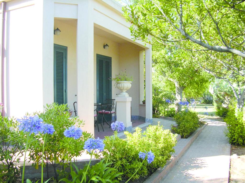 a porch of a house with blue flowers and a vase at Villino Eleonora in Parghelia