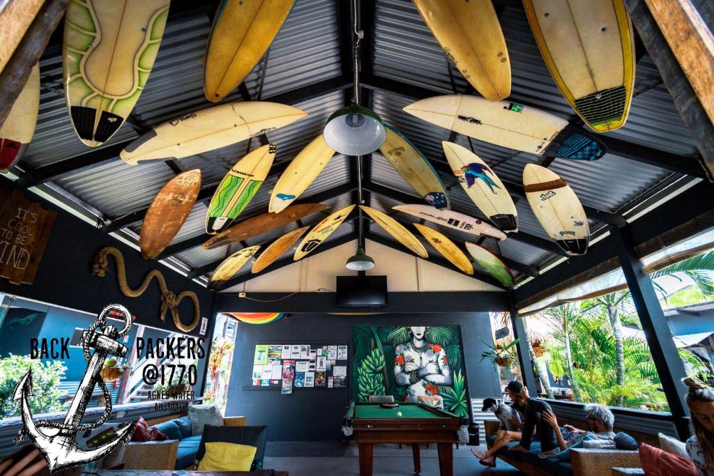 a room with surfboards hanging from the ceiling at Backpackers at 1770 in Agnes Water