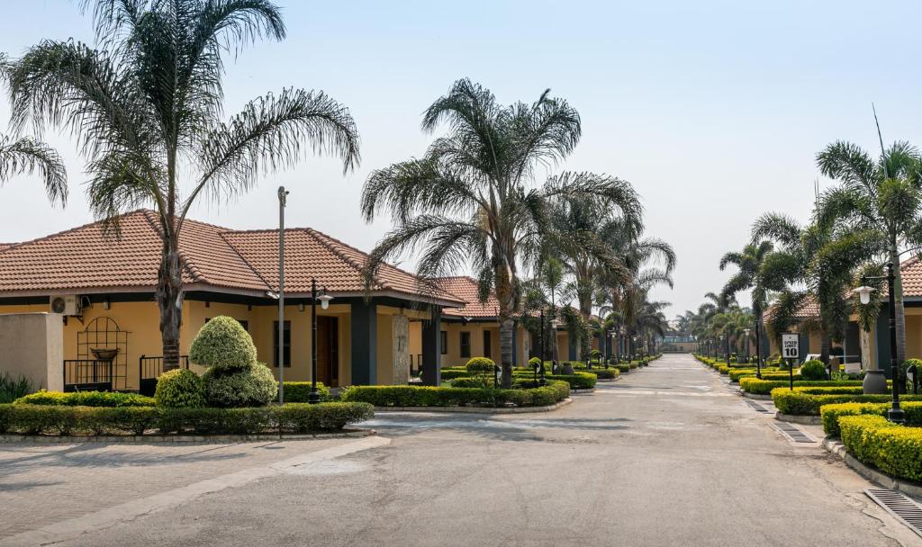 a street in front of a house with palm trees at Fallsway Villas in Lusaka