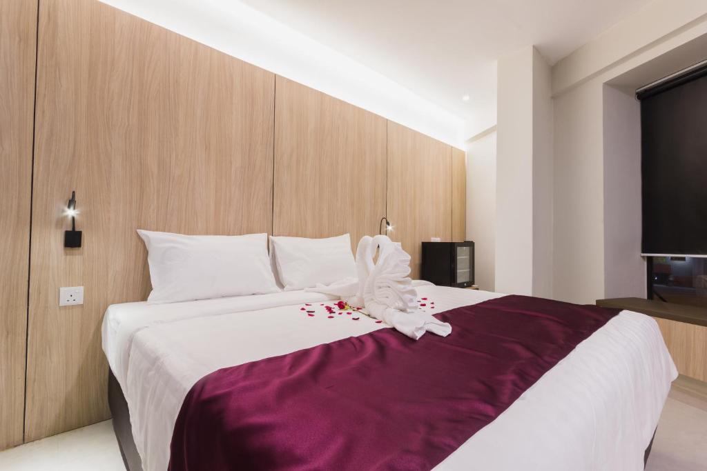 a bedroom with a large bed with a purple blanket at GM Hotel Kuantan in Kuantan