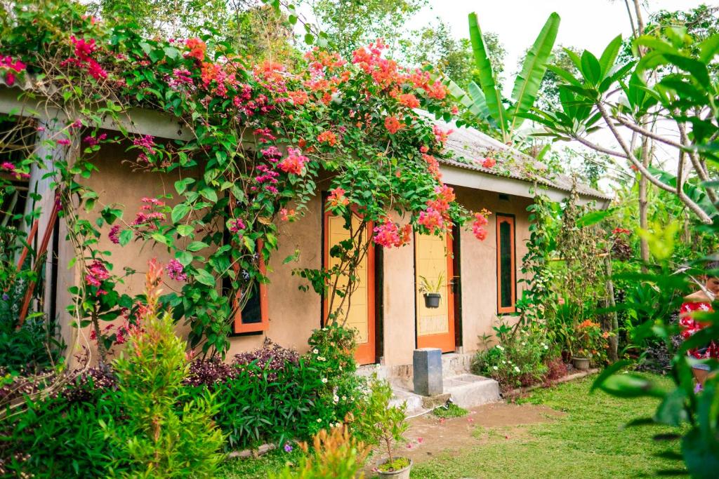 a house with flowers on the side of it at Vanilla Cottage Tetebatu in Tetebatu