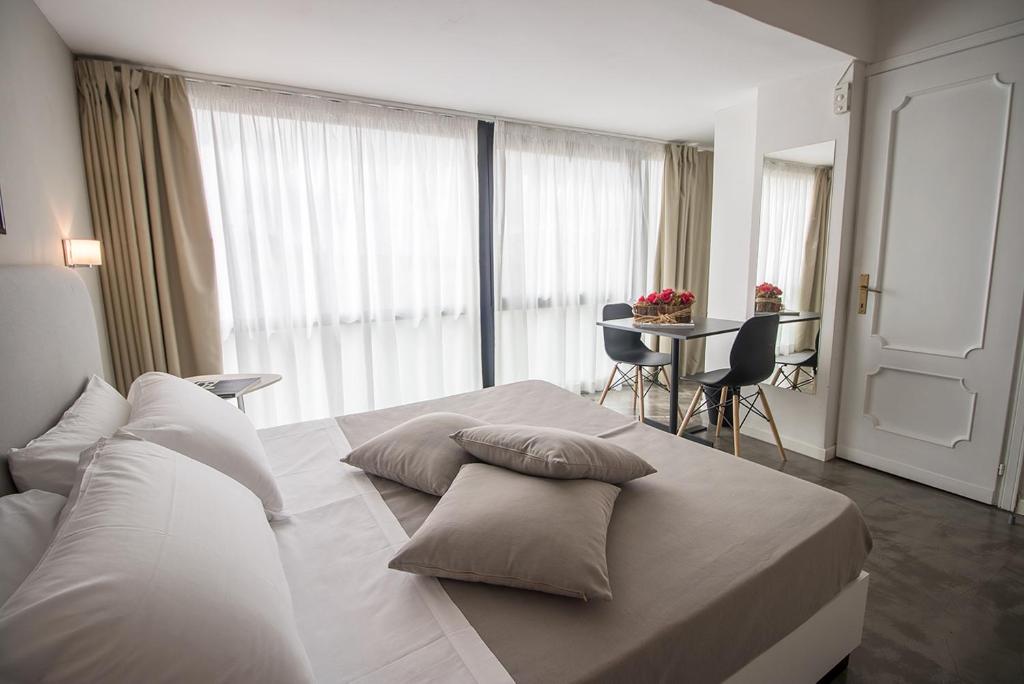 Un dormitorio con una gran cama blanca con almohadas. en Hotel Clarici, en Spoleto