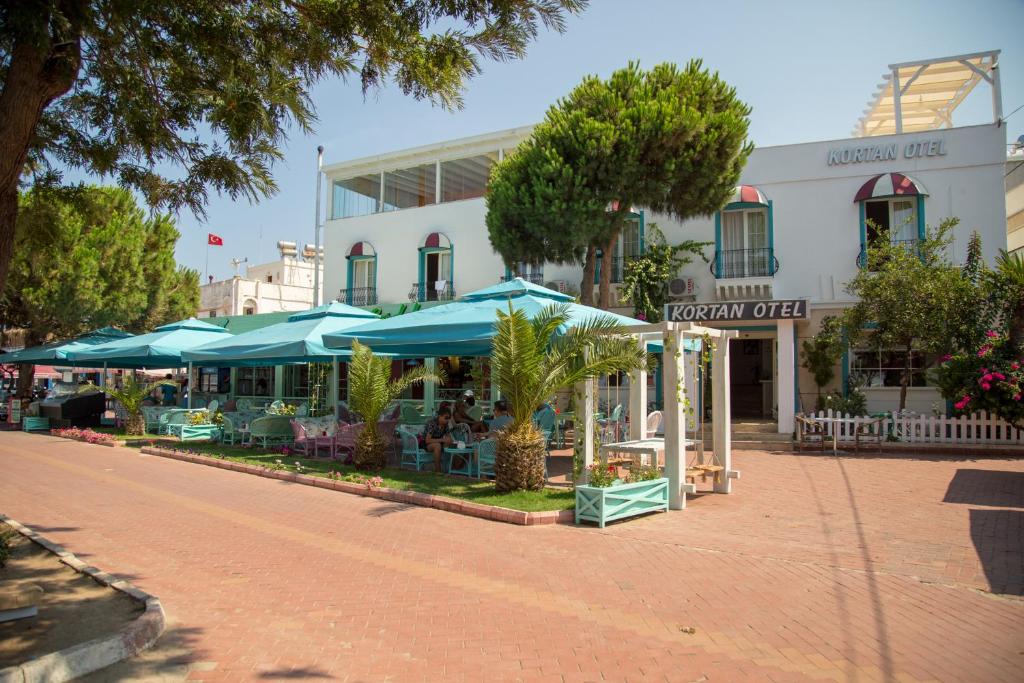 ein Gebäude mit blauen Sonnenschirmen auf einer Straße in der Unterkunft Kortan Hotel in Turgutreis