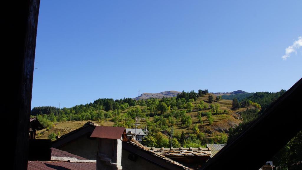 a view of a mountain from the roofs of houses at appartamenti la ginestra in Cesana Torinese