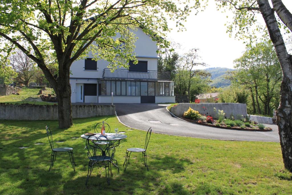 une table et des chaises dans l'herbe devant une maison dans l'établissement HippoLits, à Châtel-Guyon