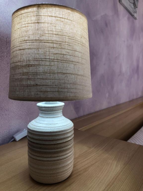 a lamp sitting on top of a wooden table at SweetHome Fabio&Stefy in Guidonia