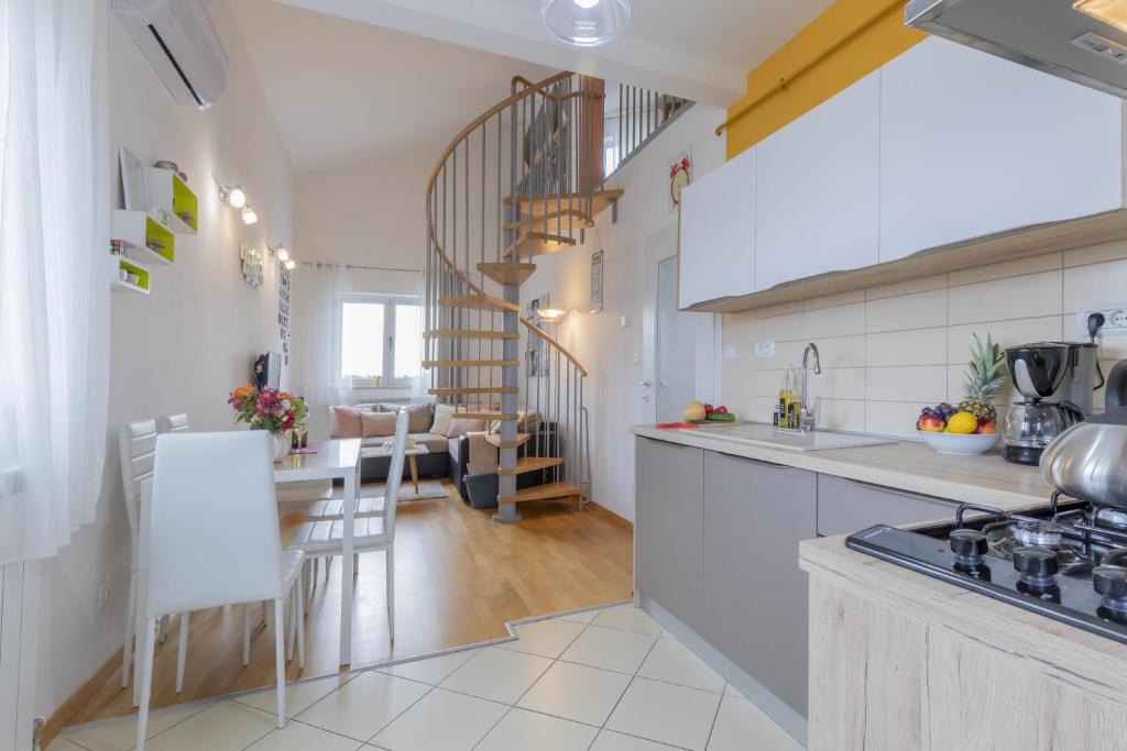 kuchnia z białymi blatami i jadalnią w obiekcie Center Penthouse Apartment w Puli