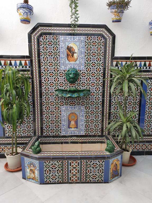 a fountain in a room with potted plants at SevillaDream in Seville