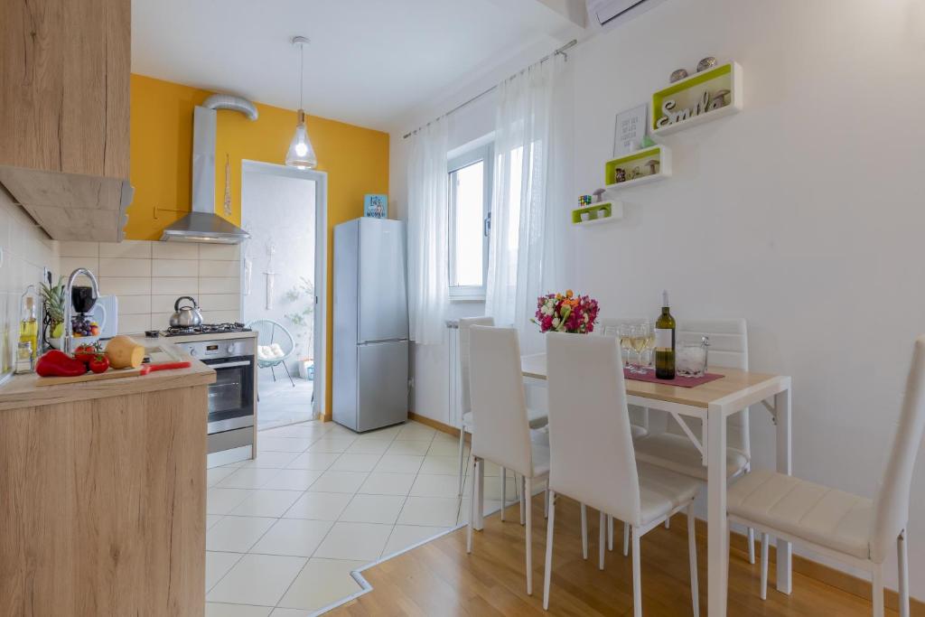 kuchnia ze stołem, krzesłami i lodówką w obiekcie Center Penthouse Apartment w Puli