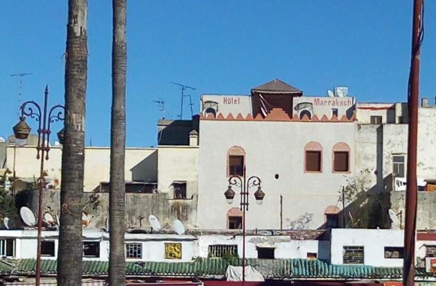 a large white building with palm trees in front of it at Hôtel Marrakech in Tangier