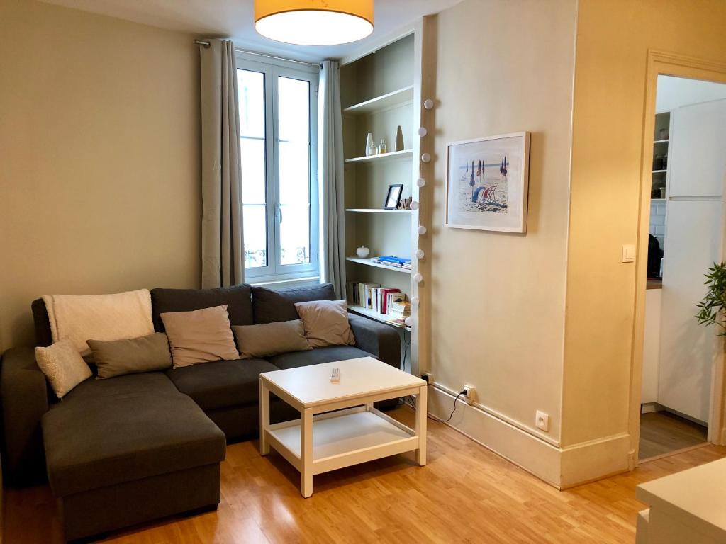 un salon avec un canapé et une table dans l'établissement Appartement VALENTINE, à Trouville-sur-Mer