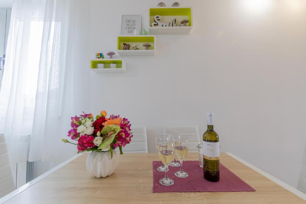 stół z dwoma kieliszkami wina i wazonem kwiatów w obiekcie Center Penthouse Apartment w Puli
