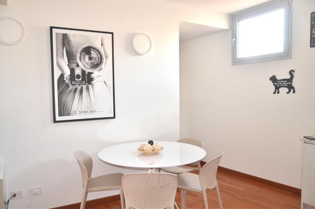 uma sala de jantar branca com uma mesa e cadeiras brancas em Tuttomondo em Pisa