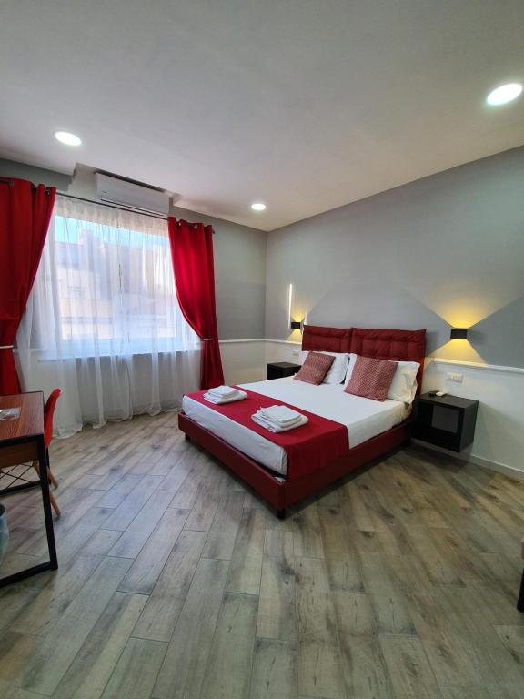 Schlafzimmer mit einem großen Bett und roten Vorhängen in der Unterkunft Dimorra Boutique Rooms in Neapel