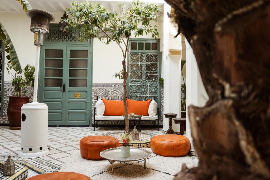 sala de estar con puerta verde y sofá en Riad Orange, en Marrakech