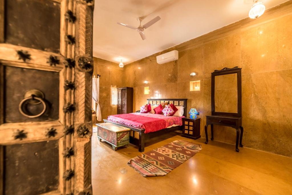 a bedroom with a bed and a dresser at Hotel Heritage House in Jaisalmer