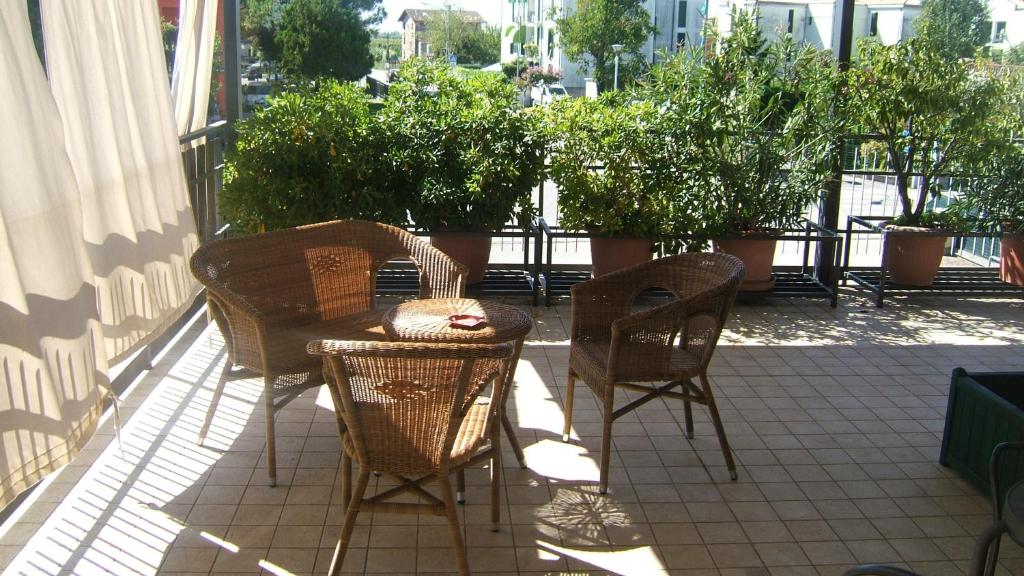 eine Terrasse mit einem Tisch, Stühlen und Topfpflanzen in der Unterkunft Locanda Canareggio in San Biagio di Callalta