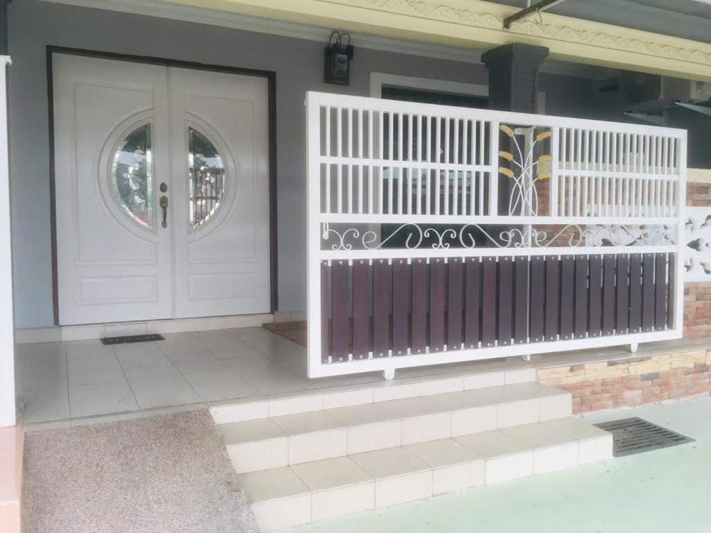a white front door of a house with a white railing at Home2Stay Damia @ Bukit Katil in Malacca