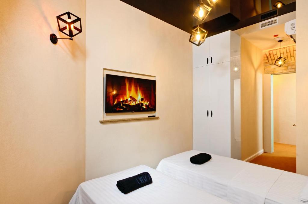 two beds in a room with a fireplace on the wall at The Key in Kyiv