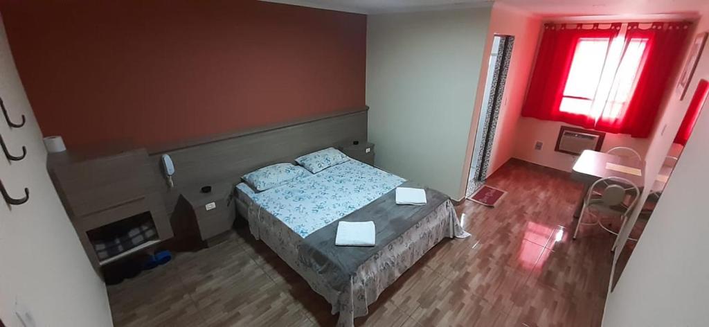1 dormitorio con cama y ventana roja en Charlott Hotel, en São Paulo