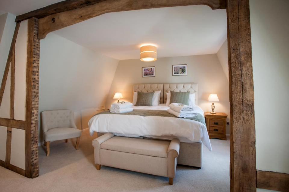 a bedroom with a large bed and a chair at Westgate Lodge at Dedham in Dedham