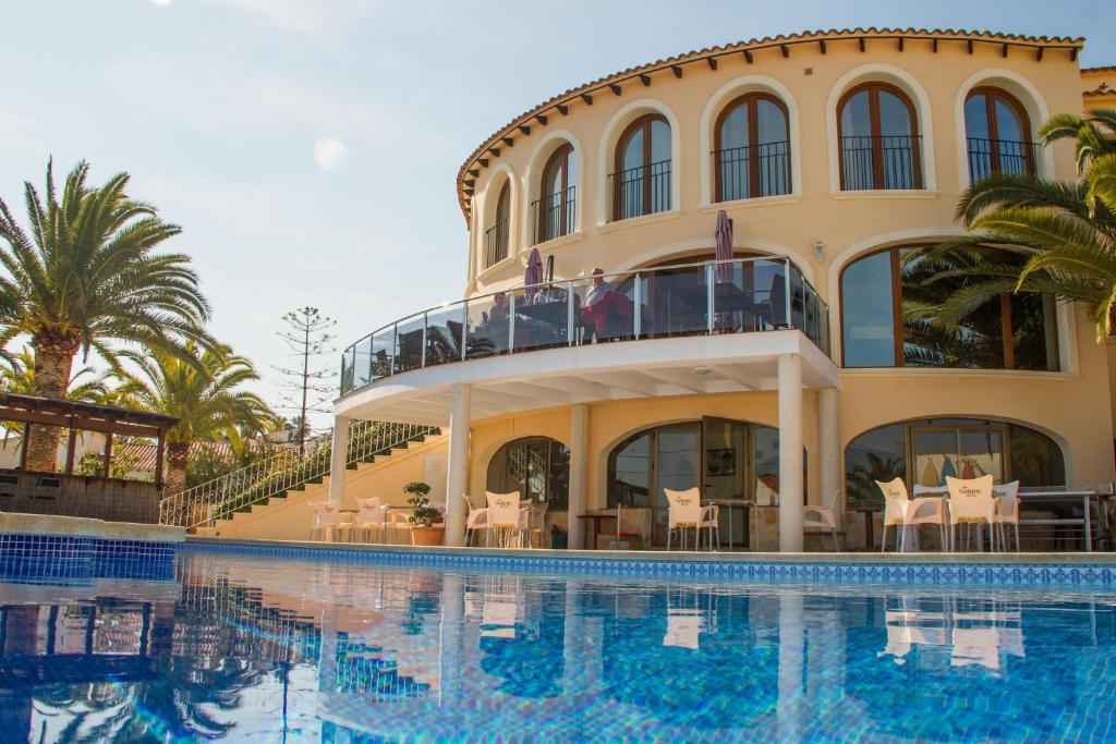 un hôtel avec une piscine en face d'un bâtiment dans l'établissement Hotel Gran Sol, à Calp