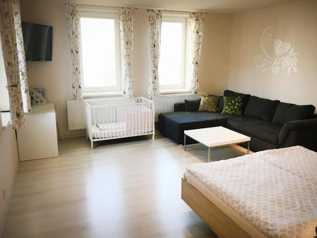 ein Wohnzimmer mit einem Sofa und einem Kinderbett in der Unterkunft Apartmán 501 in Važec