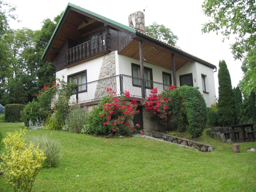 une maison avec balcon et fleurs dans la cour dans l'établissement Chata Mila, à Pecka