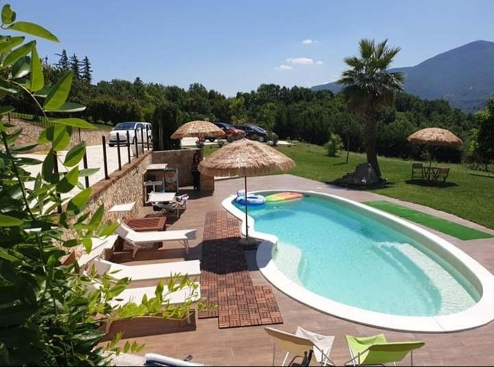 una grande piscina con sedie e ombrelloni di B&B La Bella Vista a Melfi