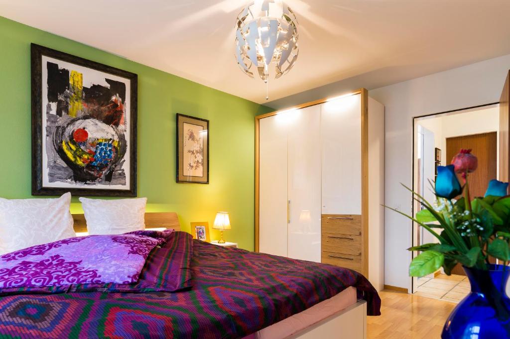 um quarto com paredes verdes e uma cama roxa em Modern, Cozy Large Apartment with Terrace in Basel- Allschwil em Allschwil