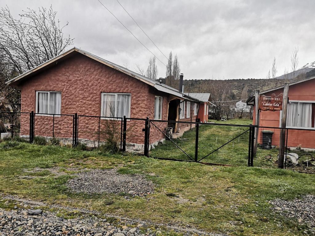 una casa con una valla delante de ella en Cabañas Kela, en Bahía Murta