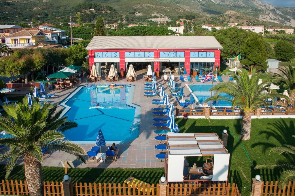 a resort with a large swimming pool with palm trees at COSTAS HOTEL in Zakynthos