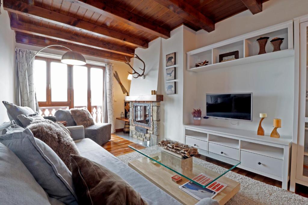 a living room with a couch and a tv at EGUA de Alma de Nieve in Baqueira-Beret