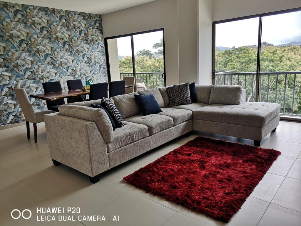 a living room with a couch and a red rug at JACO in Jacó