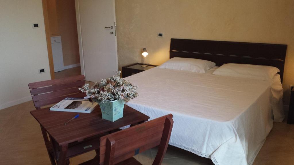 1 dormitorio con 1 cama grande y 2 mesas de madera en B&B Azzurra, en Pescara
