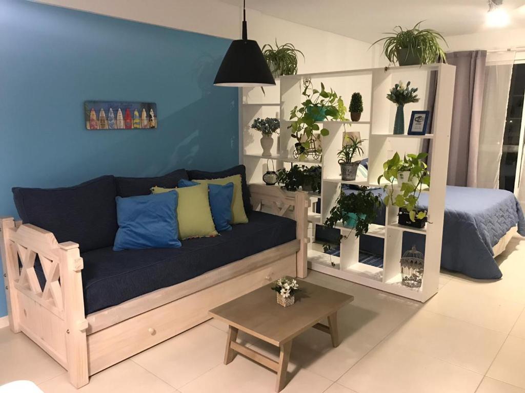 uma sala de estar com um sofá e muitas plantas em Apartamento Costa del Sol em Mar del Plata