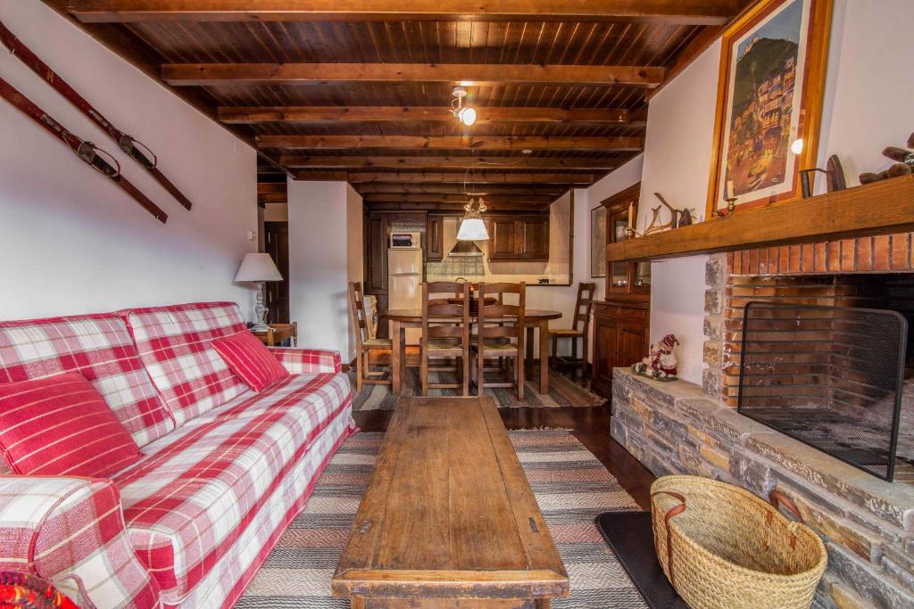 ein Wohnzimmer mit einem Sofa und einem Kamin in der Unterkunft NOGUERA de Alma de Nieve in Baqueira-Beret