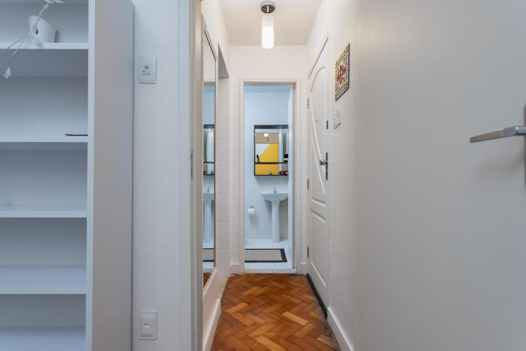 a hallway with white walls and wood floors at Cafofo Nice in Rio de Janeiro