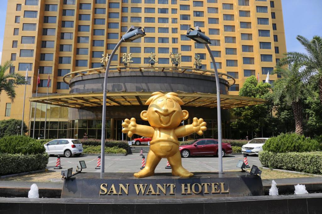 una gran estatua de oso amarillo delante de un edificio en San Want Hotel Shanghai en Shanghái