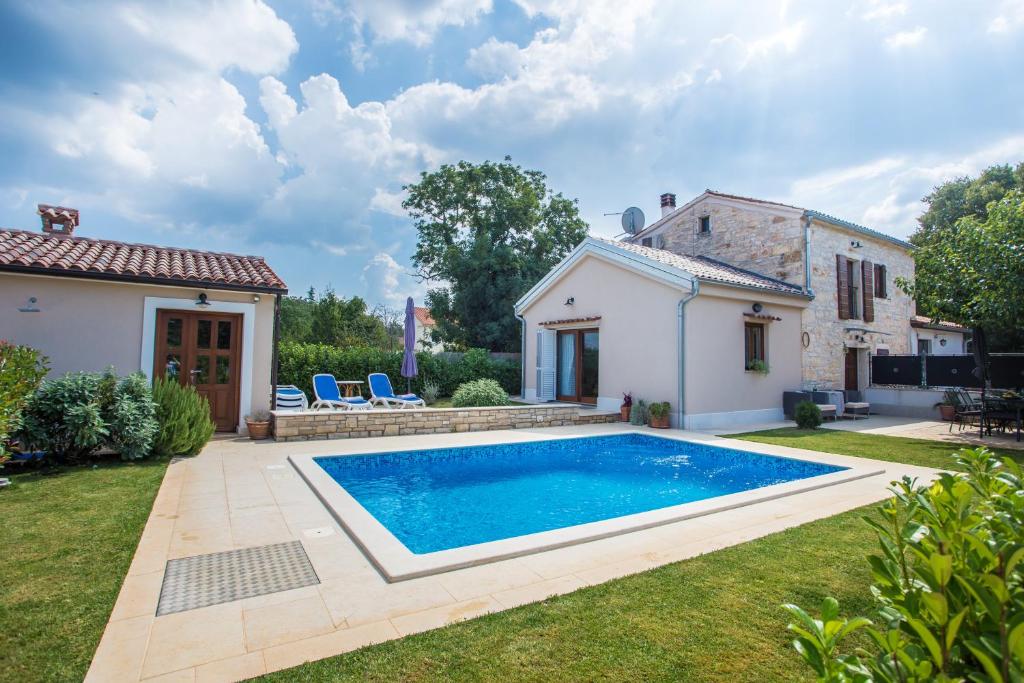 a house with a swimming pool in a yard at Casa Roza in Višnjan