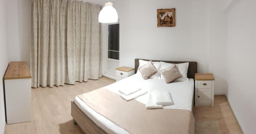 a bedroom with a white bed and a window at Apartament BelleView in Tulcea