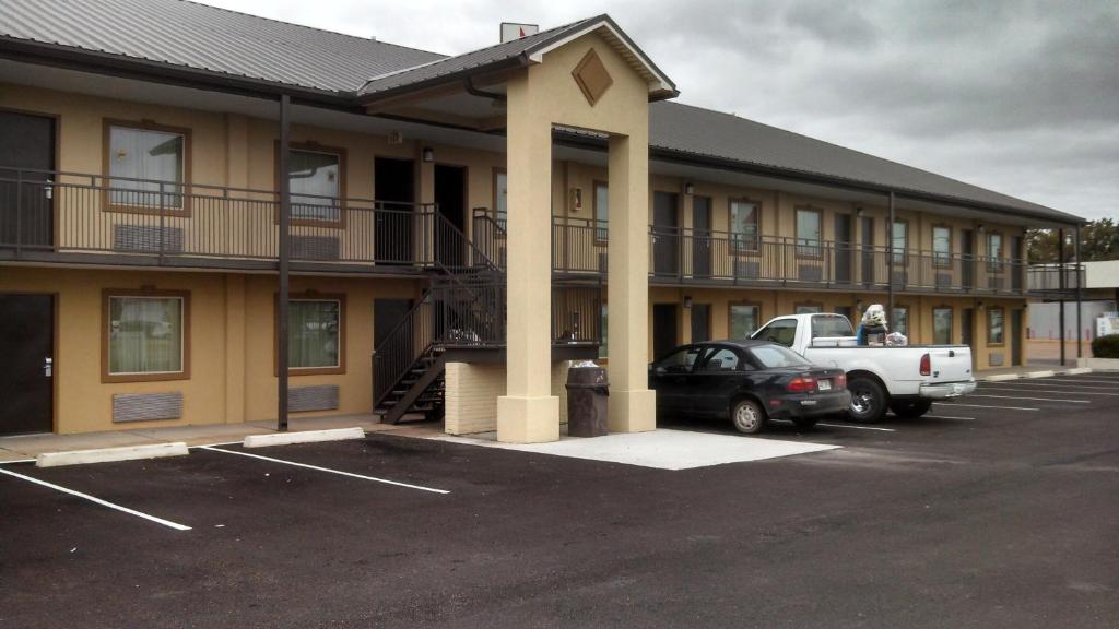 a building with a car parked in a parking lot at Relax Inn Heth in Shell Lake