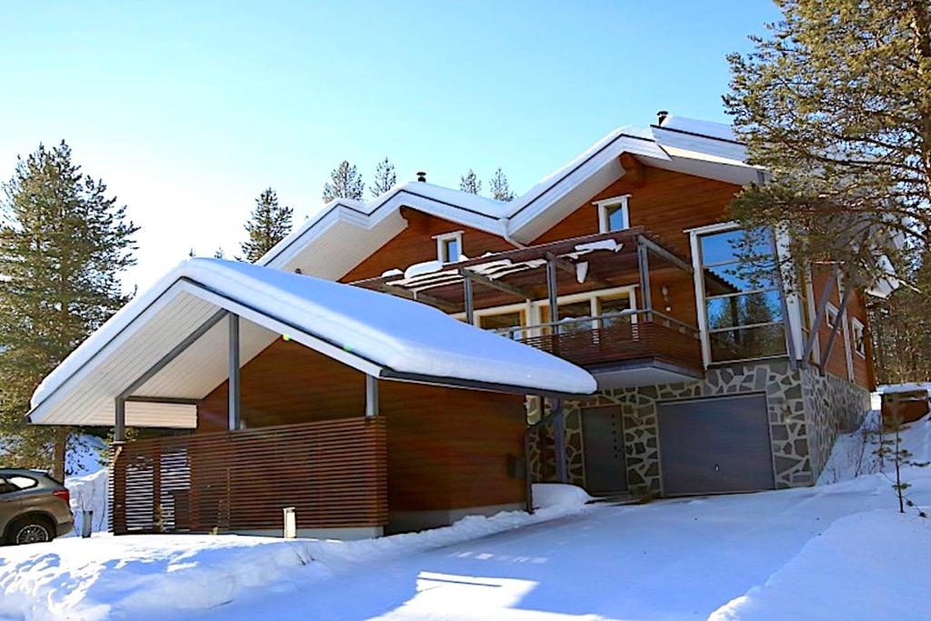 a house with snow on the front of it at Levillas Kätkänpolku Villas in Levi