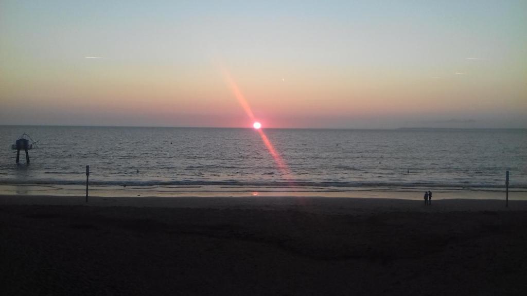 a sunset on the beach with a rainbow in the sky at perle rare à énergie positive in Saint-Michel-Chef-Chef