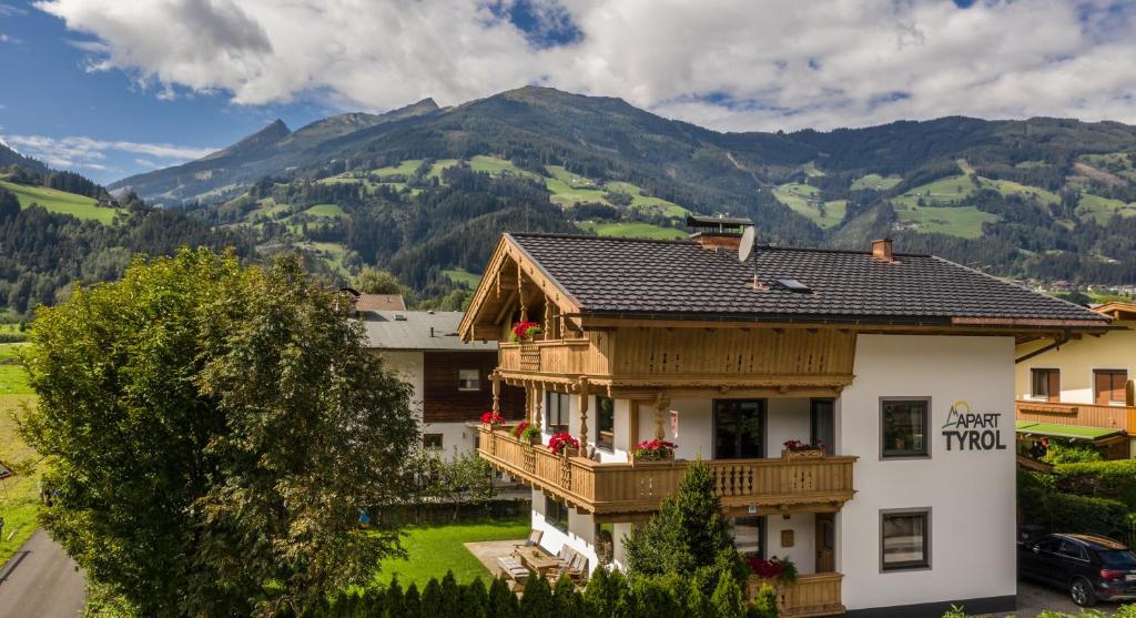 a house with a balcony and mountains in the background at Apart Tyrol in Uderns