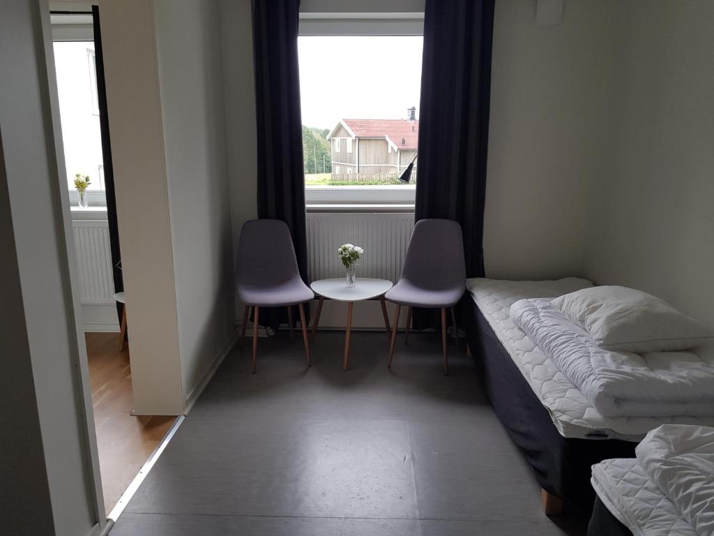 a room with two beds and a table and two chairs at Alkoven Logi in Ullared