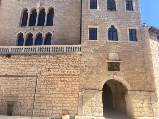 un grande edificio in mattoni con un arco davanti di Villa Castel a Bale (Valle)