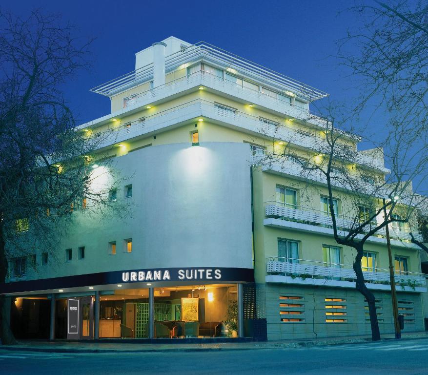 un gran edificio blanco con luces encendidas en Urbana Suites en Mendoza