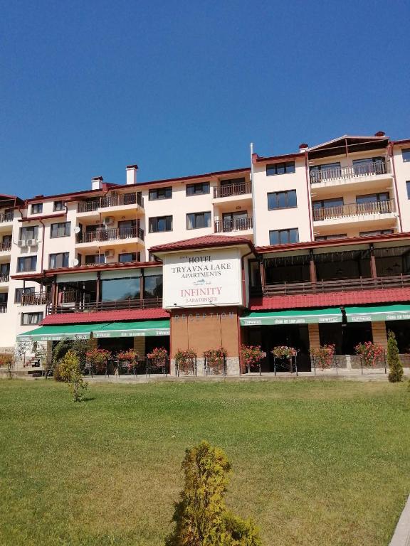a large apartment building with a lawn in front of it at Apartment Lake Tryavna in Tryavna